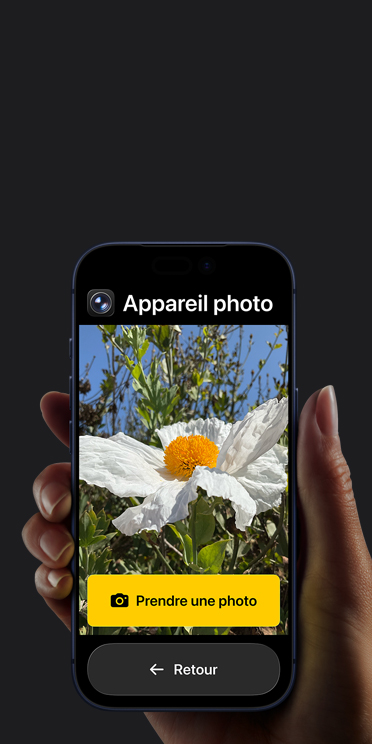 Écran d’un iPhone 17 Pro montrant l’interface simplifiée de l’app Appareil photo. Une fleur blanche est dans le cadre et le bouton Prendre une photo et celui de retour sont en dessous