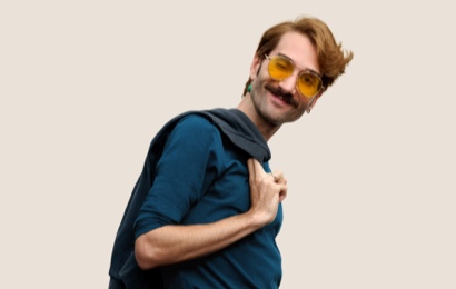 Apple Retail employee with black glasses, smiling at the camera.