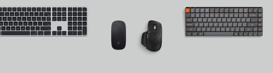 Vedere de sus a unui Mac mini argintiu într-o configurație de birou cu ecran, tastaturi wireless, mouse-uri wireless, un controler de jocuri și căști AirPods Max
