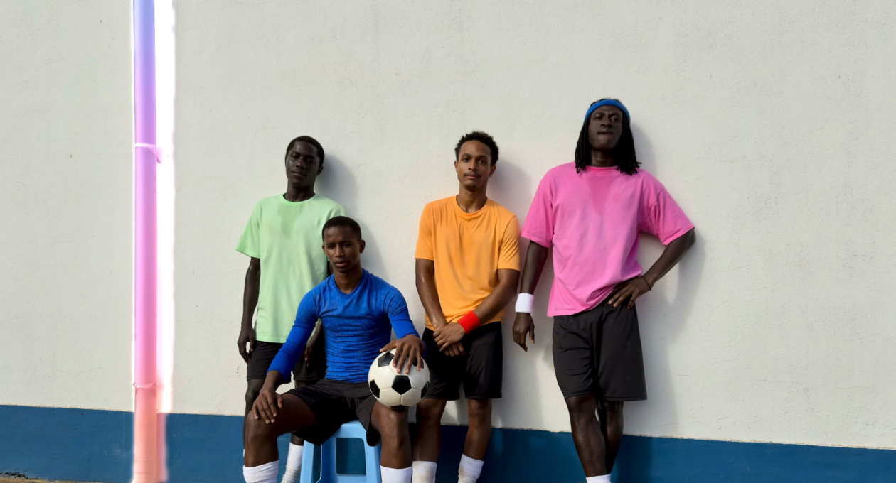 Použití funkce Vyčistit k odstranění okapové roury z fotky fotbalistů opřených o zeď