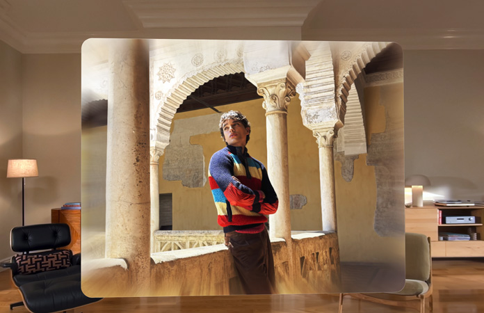 Spatial scene in a photo of a man leaning against a balcony in a winding courtyard, with depth and dimension in the surroundings