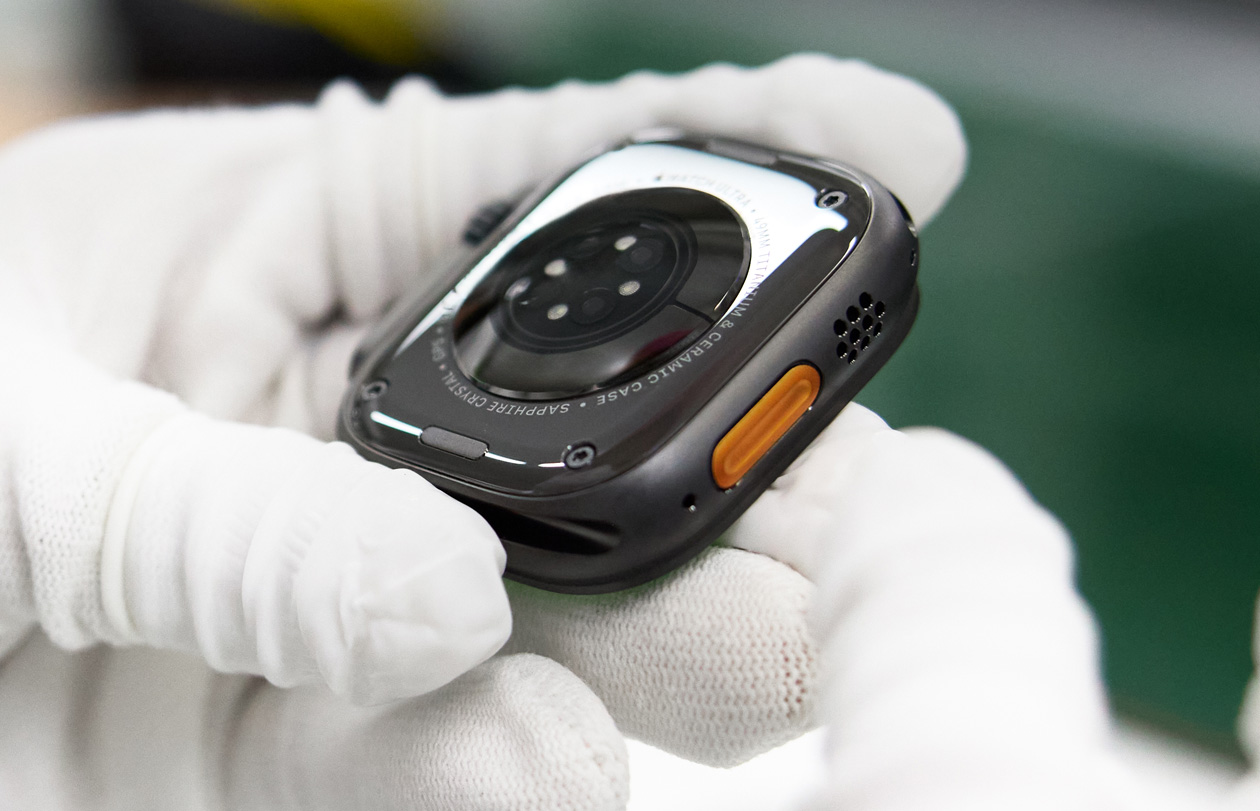 يدان بقفازات تمسكان قاعدة Apple Watch موجهة للأعلى