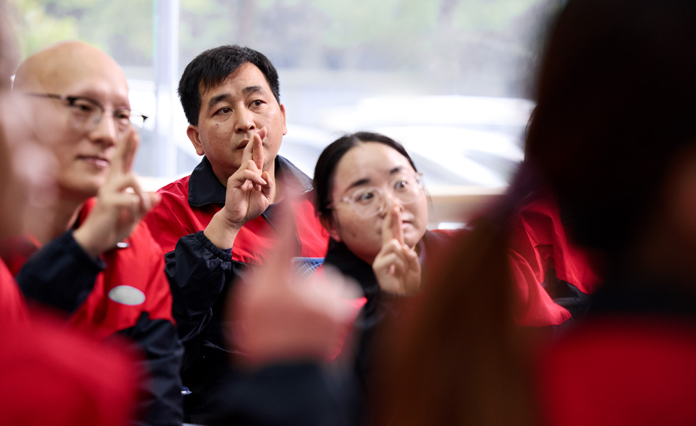 أشخاص عدة يؤدون إشارة موحدة بينما ينظرون في الاتجاه نفسه